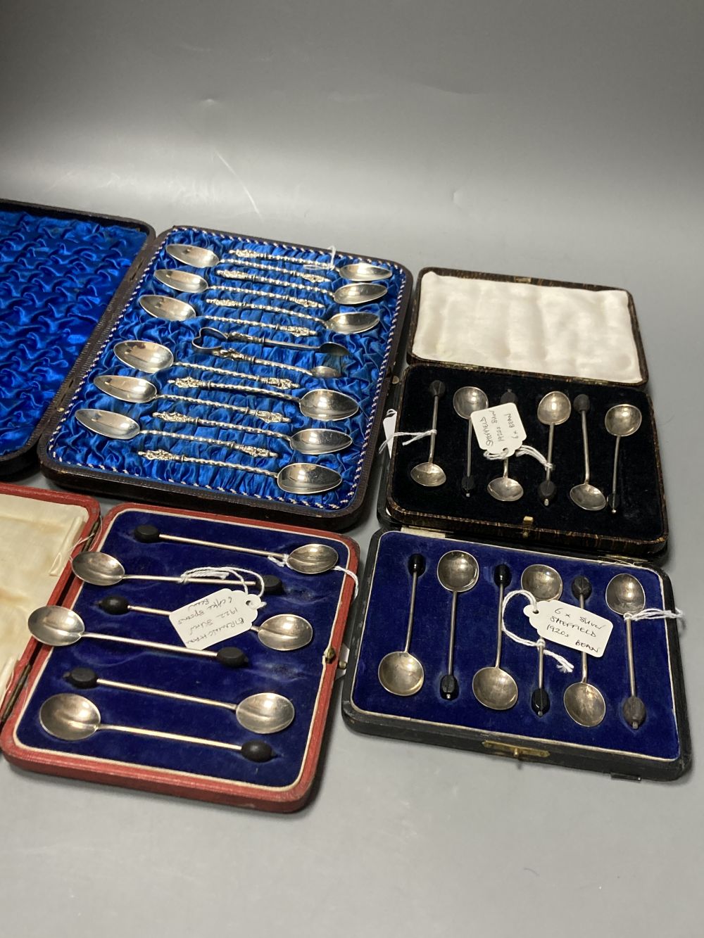 Twelve Victorian silver Apostle coffee spoons and sugar tongs, and three sets of six silver bean end coffee spoons, all cased